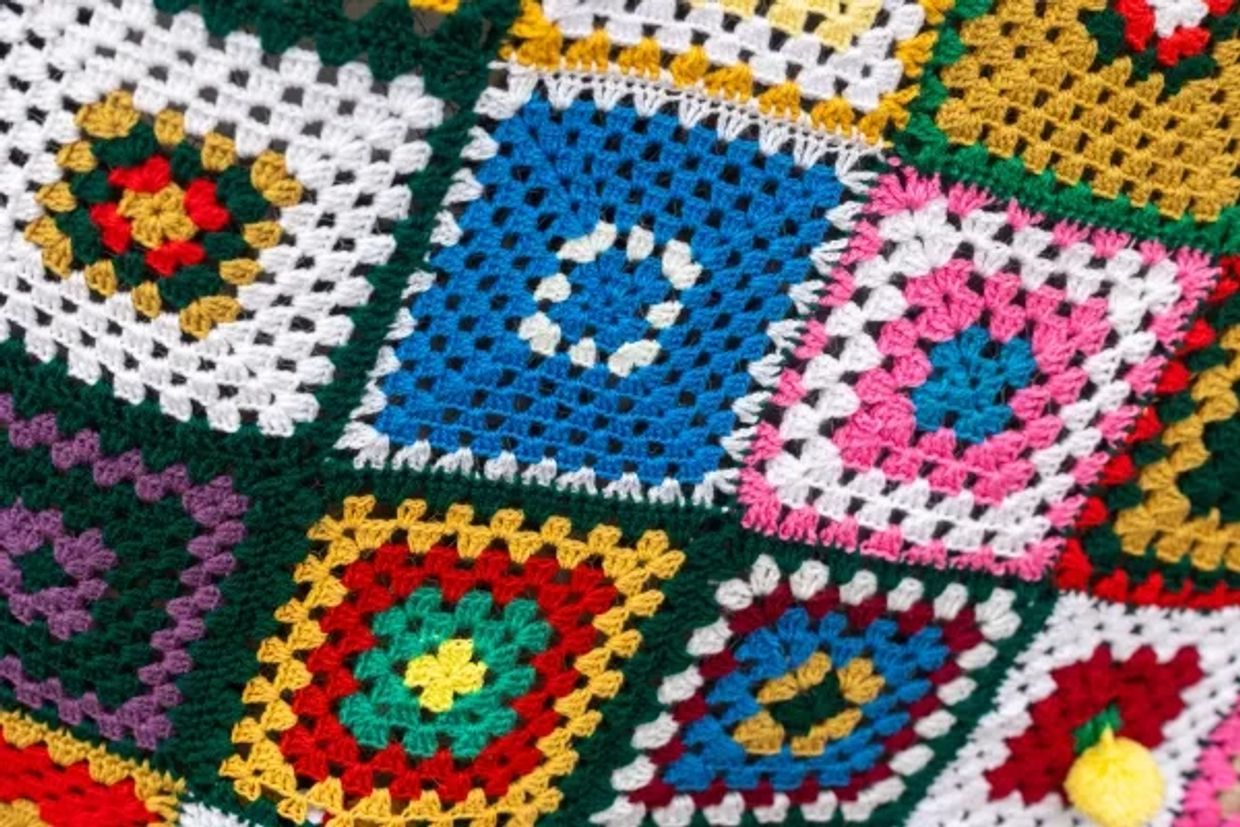Colorful crocheted granny square blanket.