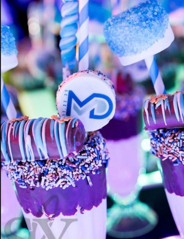 Colorful milkshakes decorated with chocolate, sprinkles, and marshmallows.