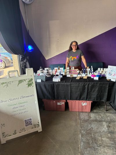 Woman selling herbal remedies at a market stall.