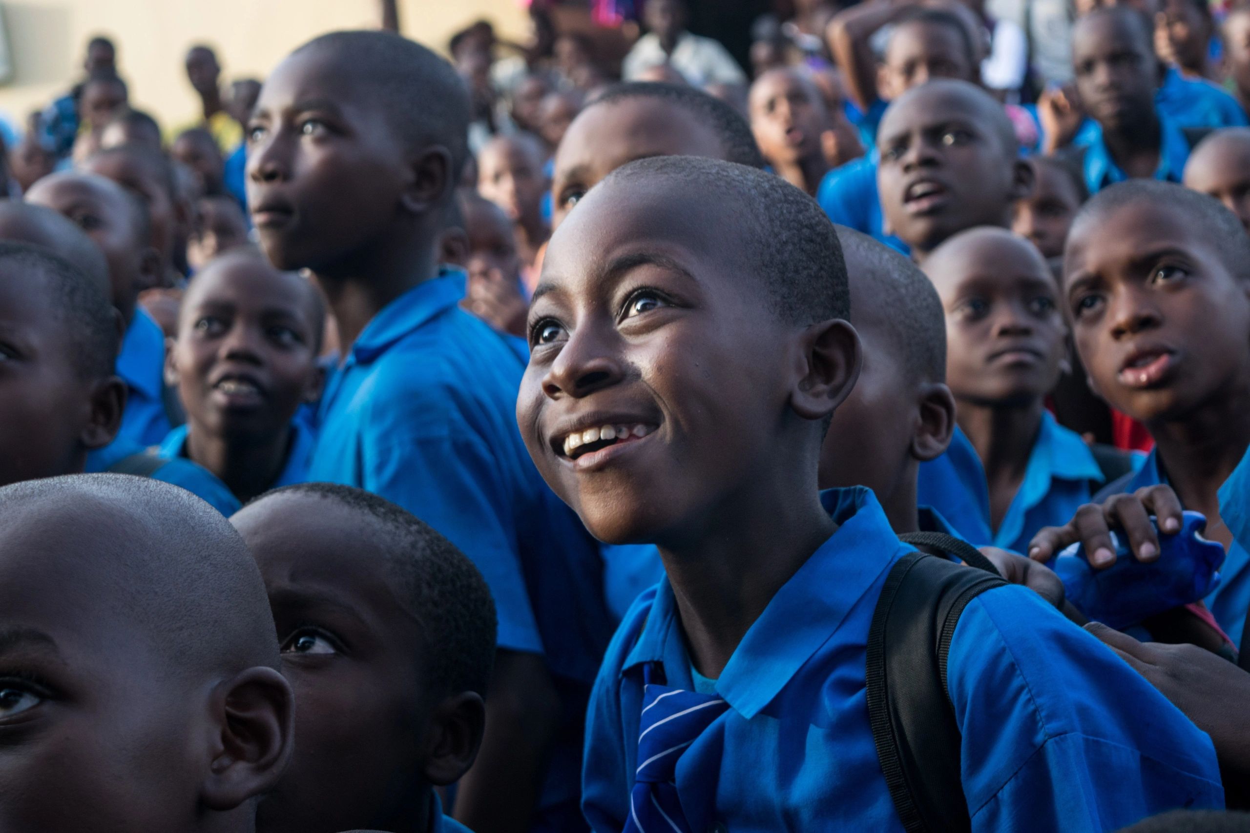 Group of attentive schoolboys in blue uniforms.