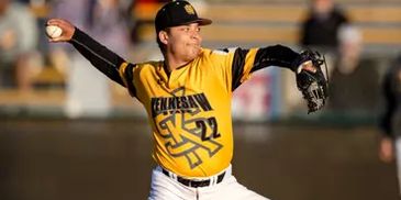 Pitcher in yellow jersey throwing a baseball.