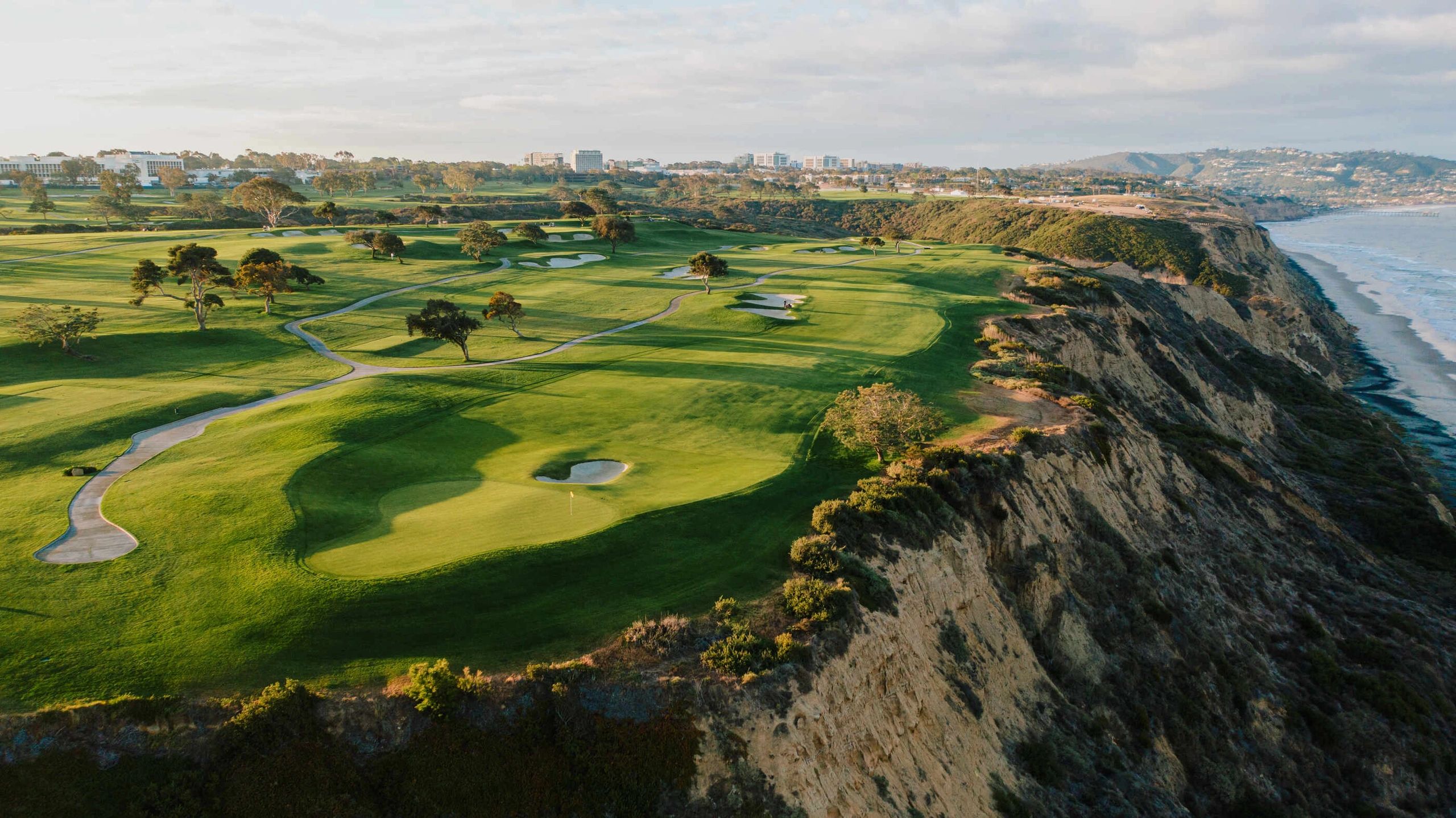 Golf course on a cliffside overlooking the ocean.