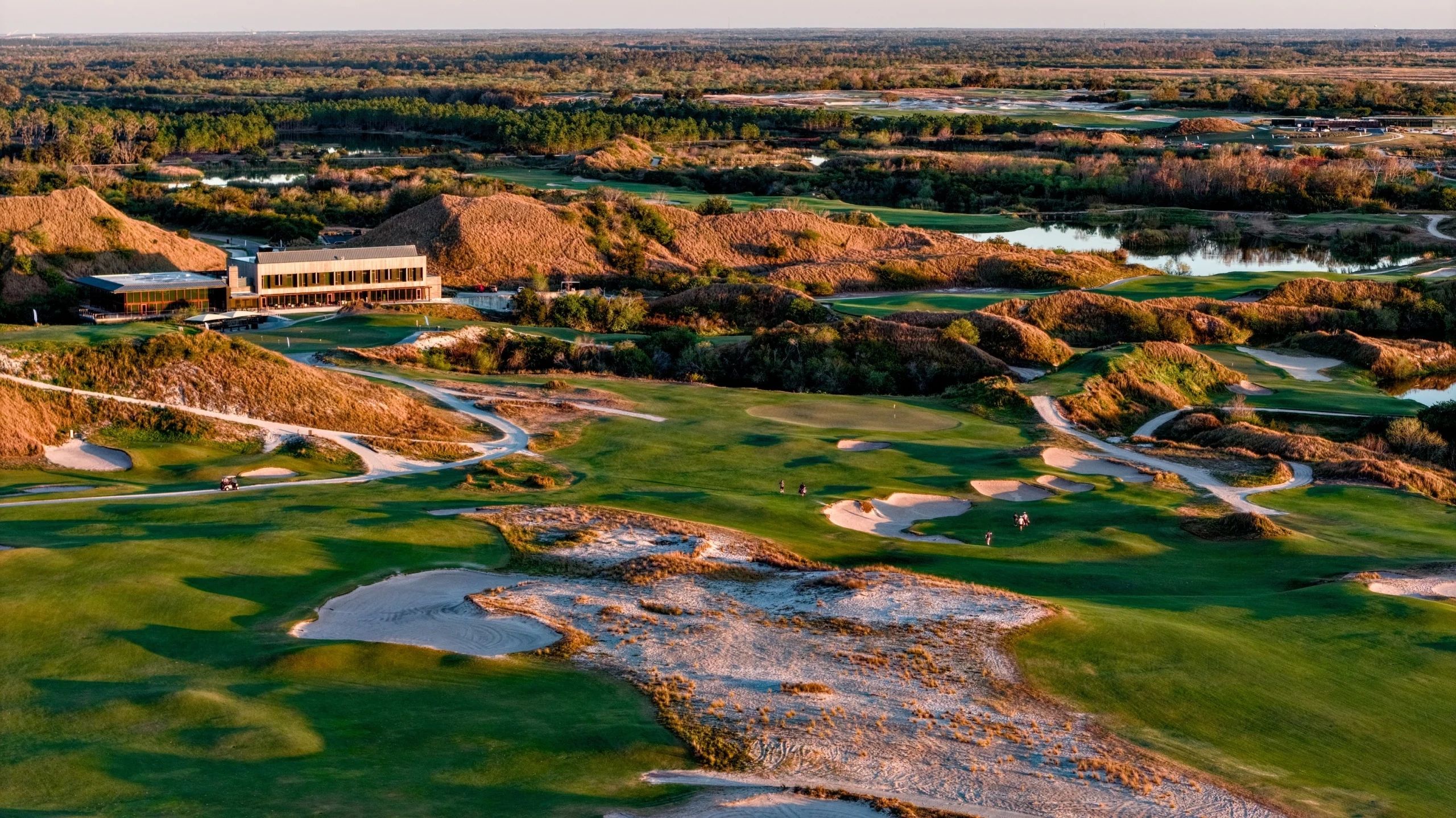 A scenic golf course with sand traps and a clubhouse.