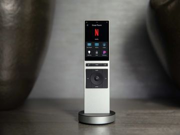 A sleek modern remote control standing on a round base.