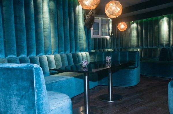 Luxurious velvet seating with ambient lighting in a modern nightclub.
