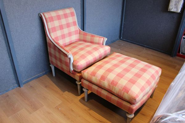 Checkered armchair with matching ottoman on wooden floor.