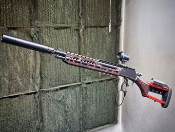 Custom rifle with suppressor and scope.