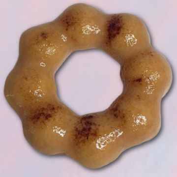 A glossy, ring-shaped pastry with a bumpy texture and brown spots.