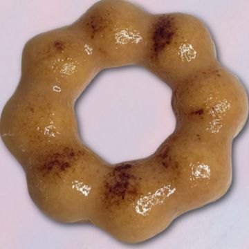 A glossy, ring-shaped pastry with a bumpy texture and brown spots.