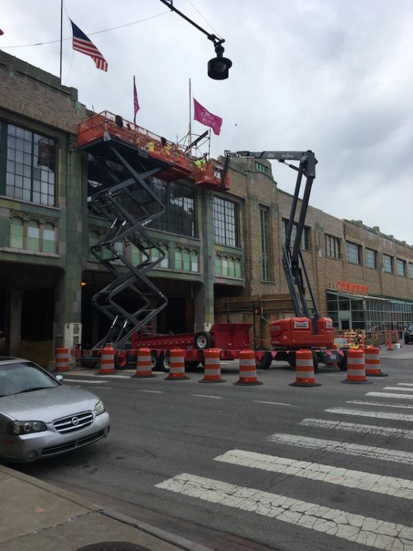 Construction workers on lifts repairing a building facade.