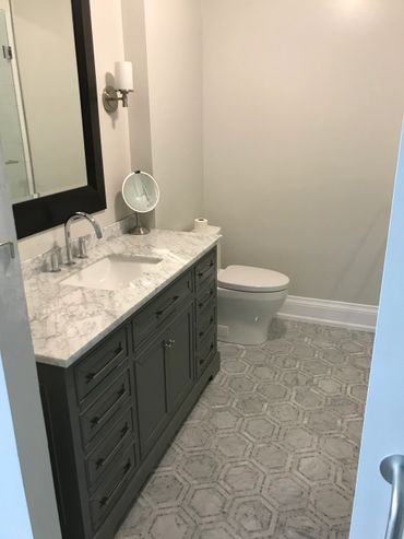 Luxurious Bathroom Renovation with Carrera Marble Counter Top and Wall Sconces.