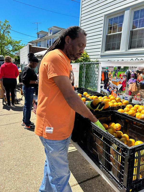 Man selecting oranges at outdoor market.