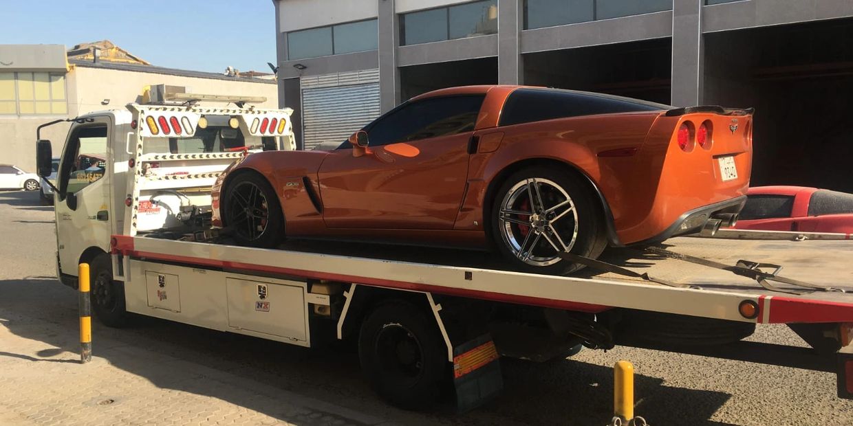 A tow truck stands firmly on the roadside, its hydraulic platform lifted with precision as it carries a broken-down car. The disabled vehicle rests securely on the flatbed, showing signs of a sudden mechanical failure, while the tow truck’s strong metal frame and bright safety lights highlight its reliability.

With steady movement and professional handling, the tow truck transports the damaged car to safety—reflecting the essential role of Alzoubi Tow Truck in providing fast, safe, and dependable roadside assistance