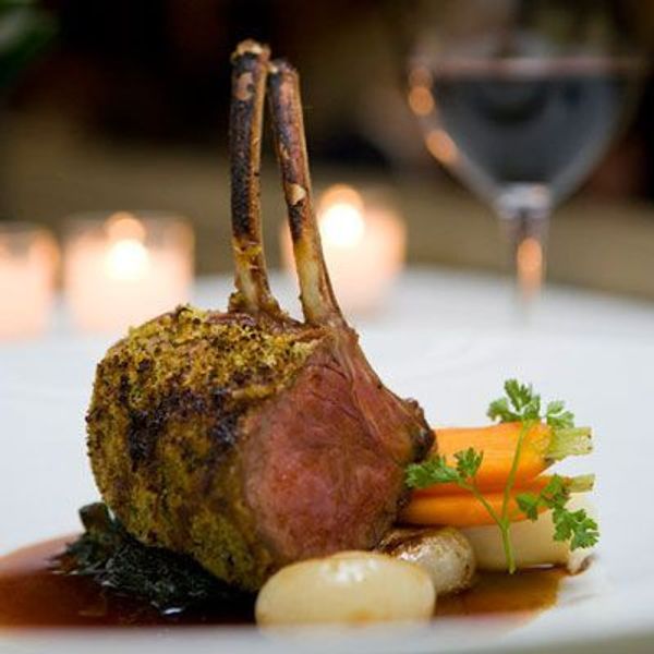 Gourmet rack of lamb with vegetables and sauce.