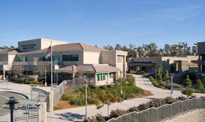 Exterior view of a modern school building under a clear blue sky.