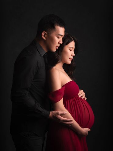 A couple tenderly embracing, celebrating pregnancy.