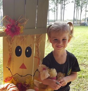 A little girl wearing a black shirt showing her face