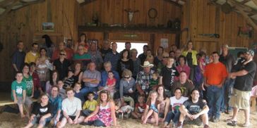 There are many people inside the house sitting and standing and looking ahead