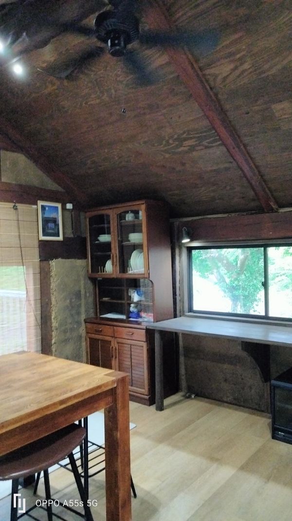 Rustic wooden room with dining table and cabinet.