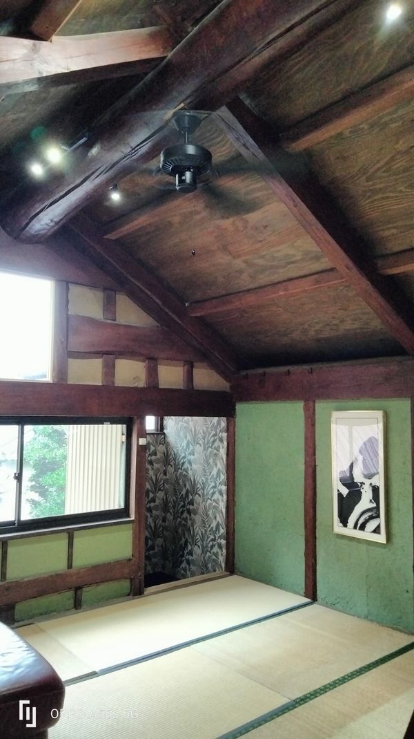 Traditional Japanese room with tatami mats and wooden beams.