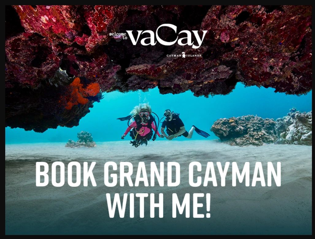 Two divers exploring underwater coral in Grand Cayman, inviting you to book a vacation.
