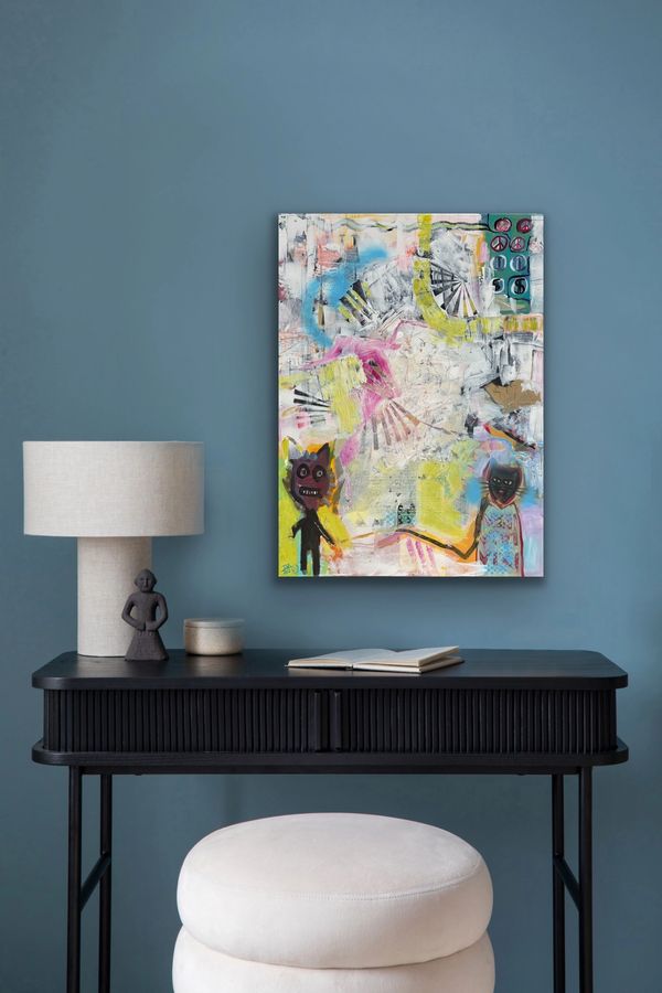 Abstract painting above a black desk with a lamp and stool.