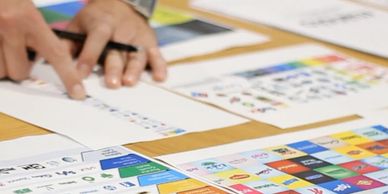 Person pointing at a printed color chart.