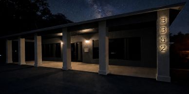 Dark house exterior with illuminated numbers at night.