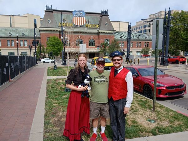 Three people posing in front of a historic Union Pacific building.