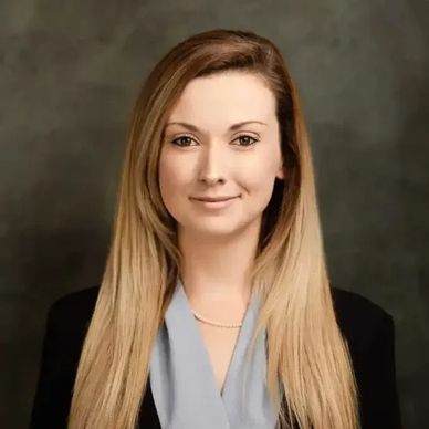 Professional portrait of a woman with long blonde hair and a confident smile.