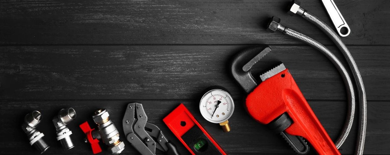 Plumbing Tools displayed on black wood background.
