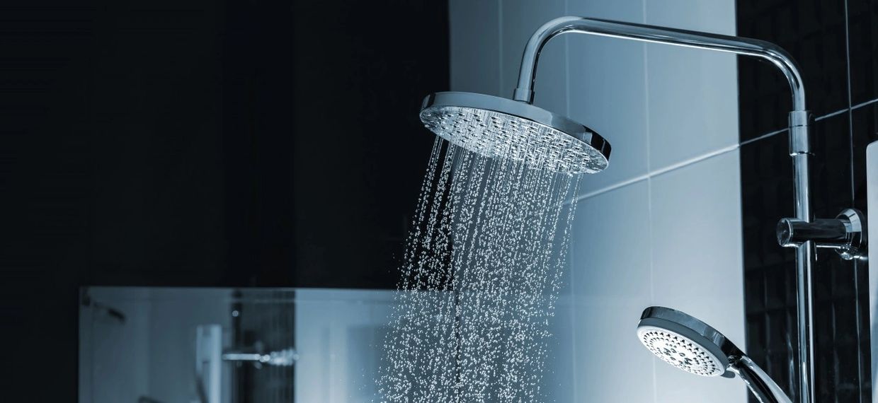 Modern showerhead with water flowing in a sleek bathroom.