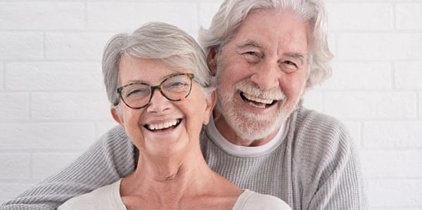 Couple souriant et montrant leurs implants dentaires