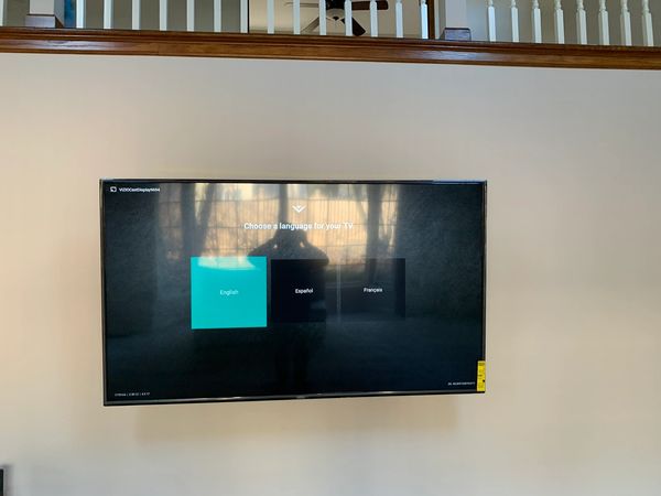 TV installed on to the drywall with an electrical outlet behind the TV. 