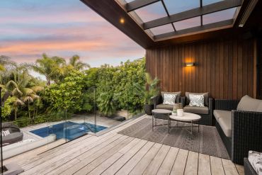 Cozy outdoor seating area by a pool at sunset.