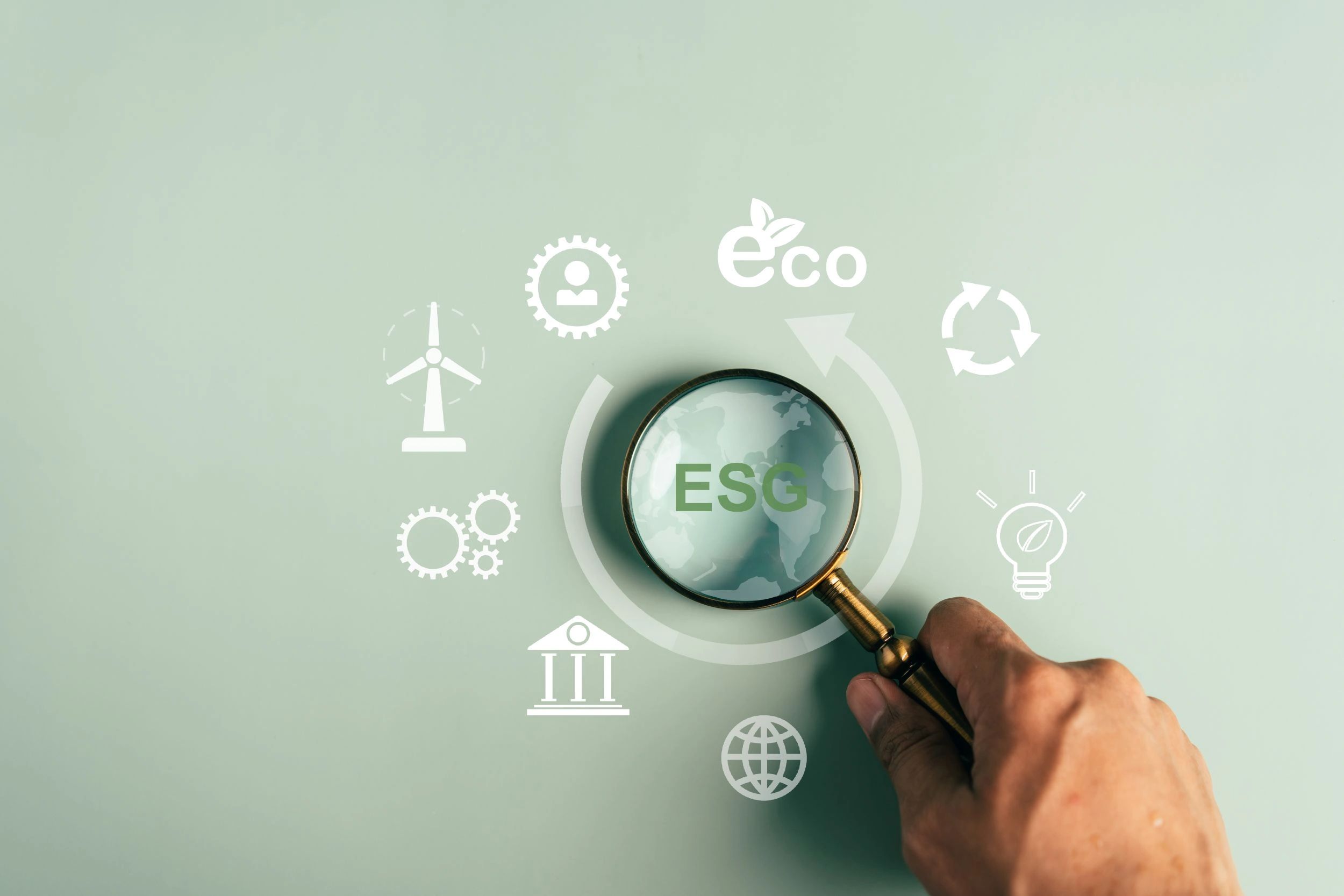 Magnifying glass focusing on ESG concepts and eco-friendly icons.