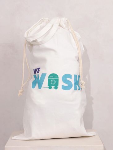 White drawstring laundry bag with "We Wash" text and washing machine graphic.