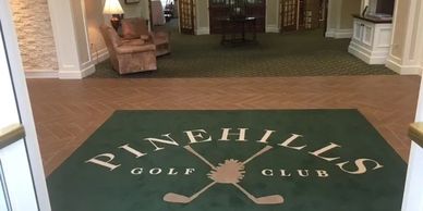 Entrance mat of Pinehills Golf Club inside a building.