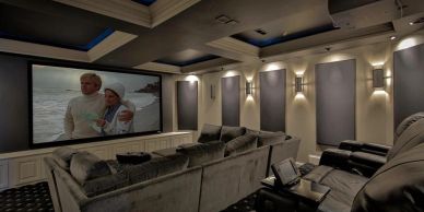 Luxury home theater room with plush seating and large projector screen.
