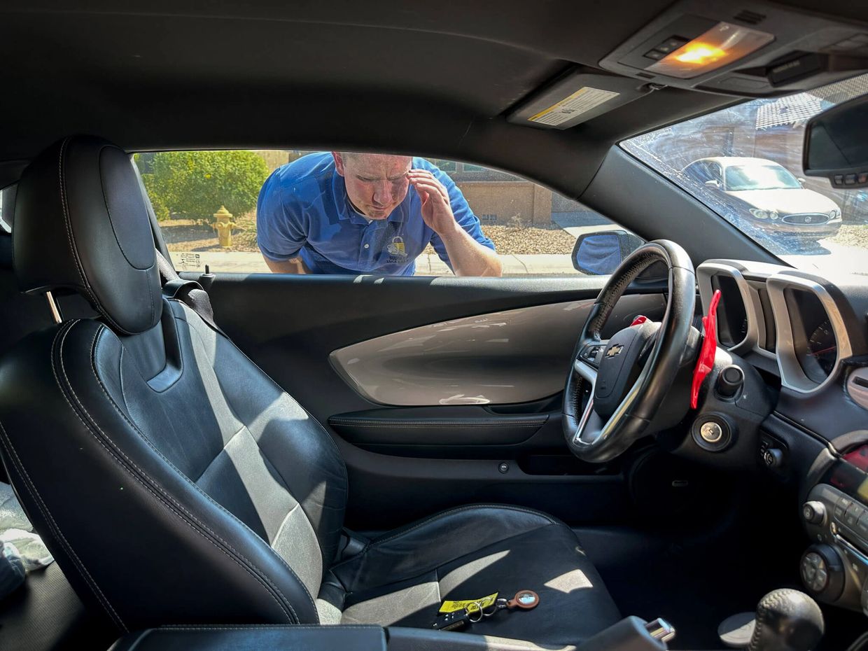 Local Locksmith looking inside of auto window with keys stuck inside of the car