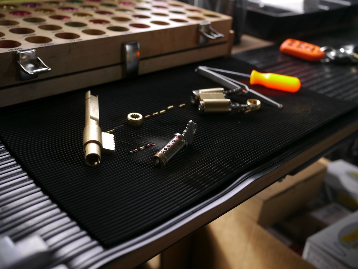 Disassembled lock components and lock picking tools on a workbench.