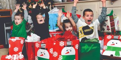 Excited children opening Christmas presents.