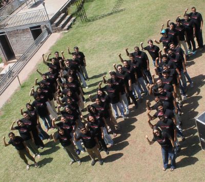 Group of people forming the letters 'M21' outdoors.