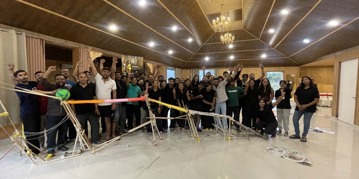 Group of people celebrating with a wooden structure indoors.