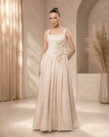 Woman wearing an elegant beige gown with floral details.