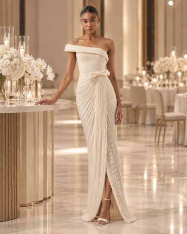Elegant woman in a white off-shoulder gown at a luxurious venue.