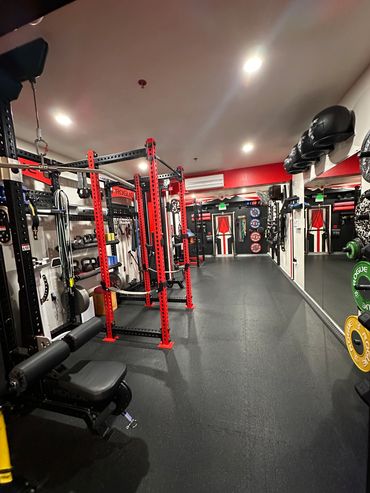 Empty modern gym with workout equipment and mirrors.