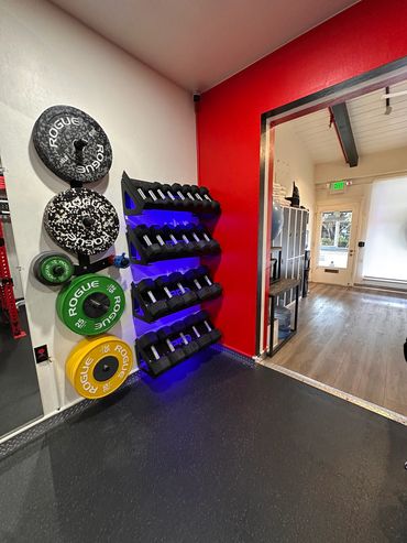 Gym corner with weights and dumbbells.