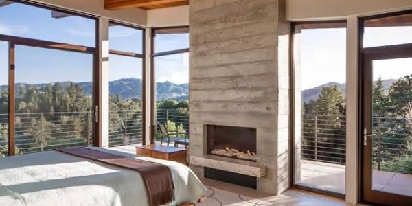 Cozy bedroom with fireplace and scenic mountain views.