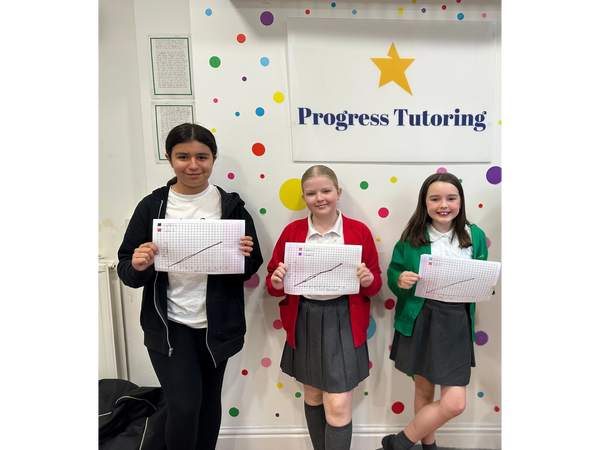 Progress Tutoring in Ormskirk and Aintree. Year 6 pupils holding up their work for SATs.
